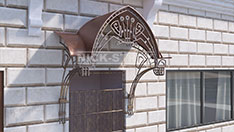 Кованый козырек оригинальной формы с металлической крышей. От 60 000 ₽ за кв.м